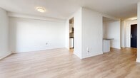 Located at 580 The East Mall in Toronto's Etobicoke neighbourhood, this single-floor unit offers a clean, modern aesthetic throughout its thoughtfully organized layout. Light-toned laminate flooring flows continuously through the living area, hallway, and kitchen, creating a cohesive and airy feel. Crisp white walls and bright finishes reflect natural light effectively throughout the space.

The living area is generously proportioned, featuring a large window that allows abundant natural light to fill the room and offers views of the surrounding area. A baseboard heating unit runs along the exterior wall beneath the window, ensuring year-round comfort.

The kitchen is efficiently designed with white cabinetry, dark countertops, and a full suite of stainless steel appliances, including a French door refrigerator, over-the-range microwave, and electric range. A peninsula counter separates the kitchen from the living space, providing additional prep area and a natural division between the two zones. Track lighting overhead ensures the kitchen is well-lit.

The bathroom features a full soaker tub and shower combination, finished with classic white subway tile extending to the ceiling, creating a clean and timeless look. The hallway entry provides a practical transition point connecting all areas of the unit, completing this well-organized and move-in ready space.