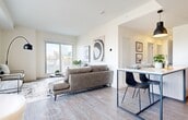 Located at 10135 108 Street NW in downtown Edmonton, Alberta, this thoughtfully designed 4-bedroom, 2-bathroom unit offers a modern open-concept layout across a single floor. Light-toned hardwood flooring flows throughout, unifying each space with a clean, contemporary aesthetic.

The open-plan living and kitchen area serves as the heart of the unit. The kitchen is outfitted with flat-panel light wood cabinetry extending to the ceiling, stainless steel appliances, a subway tile backsplash, and a central island with a marble-style countertop that doubles as a dining bar. A dedicated dining area sits adjacent, illuminated by a bold pendant light. The living room benefits from large windows that frame city views, filling the space with natural light.

A well-proportioned hallway connects the private quarters, its white walls accented by framed artwork and recessed lighting overhead. Each of the four bedrooms features neutral tones, built-in sliding closets, and direct hallway access. The primary bedroom provides a comfortable and quiet retreat. Both bathrooms are finished with tile flooring and clean, modern fixtures.

This unit combines functional design with contemporary finishes, making it a well-appointed urban residence in the heart of Edmonton.