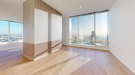 Located in Los Angeles, this generously scaled 5-bedroom, 7-bathroom residence offers a refined modern living experience across a single floor. Wide-plank oak hardwood flooring flows throughout, complementing the clean white walls and recessed lighting that define the space's bright, minimalist aesthetic.

The open-concept kitchen is a standout feature, centered around a large waterfall-edge island beneath three elegant gold pendant lights. Custom cabinetry in a warm wood tone pairs with high-gloss white upper cabinets, a marble backsplash, and integrated professional-grade appliances, including a built-in wall oven and coffee system.

Each of the five bedrooms offers generous proportions and ample natural light. Select rooms feature dramatic floor-to-ceiling windows framing sweeping panoramic views of the Los Angeles skyline. The primary suite includes a spacious custom walk-in closet with built-in shelving, drawers, and integrated LED lighting in a matching light oak finish.

The seven bathrooms present distinct design identities — one features warm wood-paneled walls, dark geometric chevron tile flooring, and modern sconce lighting, while another showcases Calacatta marble floors and a soaking tub with brushed gold fixtures.

A dedicated laundry room houses side-by-side washer and dryer units beneath ample white cabinetry. Two pantries and eight closets throughout provide exceptional storage capacity, rounding out this thoughtfully designed urban residence.
