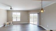 Located at 18300 Wheeler Rd in Westfield, Indiana, this single-floor residence offers a thoughtfully designed open-concept layout that seamlessly connects the living and kitchen areas. The living space features rich dark hardwood-style flooring, warm neutral-toned walls, crown molding, and a ceiling fan, creating a comfortable and inviting atmosphere. Sliding glass doors lead to a private balcony, allowing for an abundance of natural light and outdoor views.

The kitchen is a standout feature, boasting rich dark-stained cabinetry, granite countertops, stainless steel appliances including a refrigerator, microwave, and range, as well as a peninsula with a beadboard-accented base and pendant lighting overhead. A side window provides additional natural light to the cooking space.

The bedrooms are carpeted for warmth and comfort, each featuring neutral tones and natural light from well-positioned windows. The bathrooms are finished with granite-topped dark vanities, framed mirrors, and hardwood-style flooring. One bathroom includes a tub and shower combination with tiled surroundings, while another features a single vanity with refined fixtures. The overall design maintains a cohesive, neutral palette with quality finishes throughout.