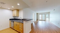 Located on Santa Monica Boulevard in the heart of Santa Monica, CA, this 3-bedroom, 2-bathroom residence offers a well-designed single-floor layout that balances comfort and functionality. The open-concept kitchen and living area serves as the heart of the home, featuring warm hardwood flooring, recessed lighting, and a seamless flow toward French doors that open onto a private balcony, flooding the space with natural light. The kitchen is equipped with light maple cabinetry, dark granite countertops, stainless steel appliances including a refrigerator, range, and dishwasher, and a peninsula with a double sink that connects to the living area. A dedicated in-unit laundry alcove with a stacked washer and dryer adds everyday convenience. The three bedrooms are carpeted and bright, each featuring windows that bring in natural light. The primary bedroom includes access to a closet, while a hallway connects the remaining rooms. The two bathrooms are finished with light maple vanities, dark granite countertops, large mirrors, and tile flooring. One bathroom features a soaking tub with classic white subway tile surround and brushed gold fixtures. A hallway with additional closet storage completes the layout, offering practical organization throughout this well-appointed Santa Monica residence.
