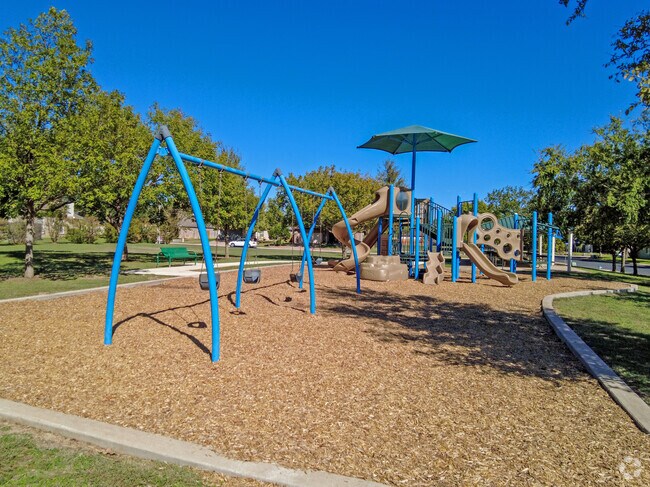 Children enjoy the swings and playscape at Katy Crossing Park.