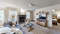 This single-story, 4-bedroom, 2-bathroom home offers a functional and comfortable layout across one thoughtfully designed floor. The living room serves as a welcoming focal point, featuring a classic fireplace with a stylish mantle, soft carpet flooring, and windows that invite natural light. Adjacent to the living room, the dining area is surrounded by multiple large windows with views to the outdoors, creating a bright and airy atmosphere ideal for everyday meals or entertaining.

The kitchen is well-equipped with warm honey-toned wood cabinetry, stone-patterned countertops, stainless steel appliances including a range, microwave, and refrigerator, and a central island that provides additional prep and dining space. Tile flooring completes the practical yet inviting farmhouse aesthetic.

The primary bedroom offers a comfortable retreat with ceiling fan, carpeted floors, and a spacious walk-in closet outfitted with dual-level wire shelving. Both bathrooms feature warm wood vanities, stone-style countertops, over-mirror lighting, and tub-shower combinations with overhead storage cabinets. The additional bedrooms provide flexible space, with one configured as a home office. A connecting hallway ties all rooms together efficiently throughout the home.
