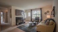 Located at 638 River Bend Ct in Newport News, Virginia, this single-floor residence offers a thoughtfully designed layout with a comfortable and cohesive aesthetic throughout. The living room serves as a welcoming focal point, featuring a classic fireplace, plush carpeting, and large windows that invite natural light. The dining area exudes a refined character with crown molding, wainscoting, and a modern light fixture overhead — an ideal setting for entertaining. The kitchen is finished with white cabinetry accented by warm wood trim, wood-look vinyl flooring, and ample counter space, complemented by a pantry with louvered bifold doors. The bedrooms are generously sized, each outfitted with soft carpeting, ceiling fans, and windows with views of the surrounding greenery. The primary bedroom provides a serene retreat with well-proportioned space and access to a private bathroom. The bathrooms are cleanly finished, featuring wood-look flooring, white vanities with wood-accented cabinetry, and a full tub-shower combination in one. A second bathroom offers a bright vanity area with strip lighting and a mirror. The overall ambiance is warm, functional, and move-in ready.