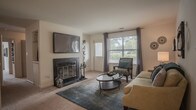 Located at 638 River Bend Ct in Newport News, Virginia, this single-floor residence offers a thoughtfully designed layout with a comfortable and cohesive aesthetic throughout. The living room serves as a welcoming focal point, featuring a classic fireplace, plush carpeting, and large windows that invite natural light. The dining area exudes a refined character with crown molding, wainscoting, and a modern light fixture overhead — an ideal setting for entertaining. The kitchen is finished with white cabinetry accented by warm wood trim, wood-look vinyl flooring, and ample counter space, complemented by a pantry with louvered bifold doors. The bedrooms are generously sized, each outfitted with soft carpeting, ceiling fans, and windows with views of the surrounding greenery. The primary bedroom provides a serene retreat with well-proportioned space and access to a private bathroom. The bathrooms are cleanly finished, featuring wood-look flooring, white vanities with wood-accented cabinetry, and a full tub-shower combination in one. A second bathroom offers a bright vanity area with strip lighting and a mirror. The overall ambiance is warm, functional, and move-in ready.