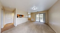 Located at 12222 Blanco Road in San Antonio, TX, this one-bedroom, one-bathroom unit offers a thoughtfully designed single-level layout that maximizes every square foot. The open-concept living and dining area is finished with neutral-toned carpet, warm beige walls, and abundant natural light streaming in through vertical blinds and a sliding glass door that opens to a private balcony with outdoor views — a standout feature of the living space.

The kitchen is efficiently designed in a galley style, featuring warm wood cabinetry, granite-style countertops, and a full suite of black appliances including a refrigerator, electric range, built-in microwave, and dishwasher. Light hardwood-style flooring runs throughout the kitchen, which connects to the main living area via a convenient pass-through counter.

The bedroom offers a comfortable footprint, plush carpeting, and a closet for storage. It connects directly to the full bathroom, which includes a dark wood vanity with stone-top counters, a toilet, and a tiled shower-tub combo. Additional closet space is found throughout the unit. The entryway provides a clean transition into the living area, completing a practical and cohesive floor plan well-suited for everyday living.