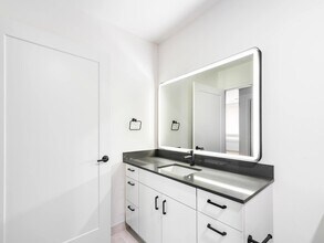 Bathroom vanity with a clean-lined sink, integrated lighting, and streamlined cabinetry creating a bright, functional space for daily routines. - Modera Bridle Trails