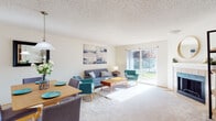 This single-floor residence offers a thoughtfully arranged layout with a seamless flow between its primary living spaces. The living room serves as the heart of the home, featuring plush carpeting, a tiled fireplace, and a large sliding glass door that floods the space with natural light and opens to an outdoor patio with views of the surrounding greenery. A dedicated dining area sits adjacent to the living room, creating a natural connection ideal for everyday living and entertaining.

The galley-style kitchen is efficiently designed with warm honey-toned cabinetry, dark stone-look countertops, wood-look flooring, and white appliances including a refrigerator, dishwasher, and electric range. Ample upper and lower cabinet storage ensures functional use of the space.

The bedrooms are carpeted and offer generous closet space with sliding wood-panel doors. Natural light filters in through windows overlooking the exterior landscaping, providing a calm and comfortable atmosphere. The two bathrooms are finished with wood-look flooring and warm cabinetry, each equipped with a shower-tub combination. Throughout the home, textured ceilings and neutral wall tones create a cohesive and inviting aesthetic well-suited for a range of residents.