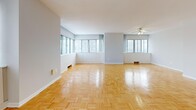 Located at 85 Thorncliffe Park Dr in Toronto's Thorncliffe Park neighbourhood, this two-bedroom, two-bathroom unit offers a well-organized and functional layout across a single floor. Warm parquet hardwood flooring runs consistently throughout the living areas and bedrooms, lending a classic, cohesive look to the space.

The spacious living room is a standout feature, with large windows that draw in natural light and frame views of the surrounding cityscape. The kitchen is efficiently designed with white cabinetry extending to the upper walls for ample storage, complemented by a full suite of white appliances including an electric range, built-in microwave, and dishwasher, alongside a double-basin sink and continuous countertop workspace. Tile flooring grounds the kitchen area.

The generously sized primary bedroom includes direct access to a dedicated bathroom and a closet, offering a practical private retreat. The second bedroom also benefits from a window with outdoor views and its own parquet flooring. The two bathrooms are clean and functional — one features a modern vanity with a white countertop and large mirror, while the second includes a full bathtub with white tile surround. Two hallways connect the rooms, ensuring a logical flow throughout the unit.
