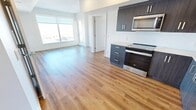 Located in the Quarry Park community of Calgary, this contemporary 2-bedroom, 2-bathroom unit offers a well-designed open-concept layout with modern finishes throughout. Warm luxury vinyl plank flooring runs seamlessly across the entire space, complementing the clean, neutral palette.

The kitchen is outfitted with sleek dark cabinetry, a herringbone tile backsplash, and a full suite of stainless steel appliances including a range, built-in microwave, dishwasher, and a French door refrigerator. The kitchen flows directly into the bright living area, which is anchored by large windows that fill the space with natural light.

Both bedrooms are well-proportioned and feature walk-in closets with wire shelving systems for organized storage. The primary bedroom benefits from oversized windows offering expansive views of the Calgary skyline and surrounding cityscape. A stacked in-unit washer and dryer adds everyday convenience.

The two bathrooms are finished with light tile flooring, modern dark-toned vanities with white countertops, and stylish globe light fixtures. The overall ambiance is bright, clean, and contemporary, making this a functional and attractive urban residence in one of Calgary's most desirable southeast communities.