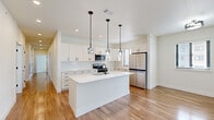 Located in the Solace Pond View community of Colorado Springs, Colorado, this thoughtfully designed single-story home offers a comfortable and modern living experience across three bedrooms and two bathrooms. The open-concept layout seamlessly connects the kitchen, dining, and living areas, creating an inviting space ideal for everyday living and entertaining.

The kitchen is a standout feature, showcasing crisp white shaker cabinets, a classic subway tile backsplash, light quartz countertops, and stainless steel appliances. A central island with a built-in sink and stylish pendant lighting adds both functionality and visual appeal, while warm wood-look flooring runs throughout the main living areas.

The spacious primary bedroom is bathed in natural light from dual windows and features a ceiling fan, plush carpeting, and access to a generous walk-in closet outfitted with wire shelving. The two additional bedrooms are well-proportioned, each with ceiling fans, natural light, and closet space — one with hardwood-style flooring and another with soft carpeting.

The bathrooms are finished with consistent, clean design elements including wood-look flooring and matte black hardware accents. Throughout the home, neutral tones, clean lines, and a digital thermostat reflect a modern, move-in-ready aesthetic well-suited to the Colorado Springs lifestyle.