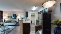 Located at 500 Williams Dr in Marietta, Georgia, this single-floor residence offers a well-designed, open-concept layout that seamlessly connects the kitchen, dining, and living areas. The kitchen is equipped with stainless steel appliances, including a refrigerator, electric range, and microwave, complemented by dark espresso cabinetry, granite-style countertops, and a peninsula with a built-in sink that opens to the main living space. Wood-style plank flooring runs throughout the common areas, adding warmth and continuity. The dining area features a pendant light fixture, while the living room offers a comfortable, open atmosphere with direct sightlines to the kitchen. Two well-proportioned bedrooms are finished with plush carpeting, large windows that invite natural light, and ample closet space. Each bedroom is served by its own full bathroom, both featuring dark vanity cabinetry with granite-style countertops, wood-style flooring, and a shower-tub combination. A dedicated laundry area and additional storage further enhance the functional layout. The overall design presents a clean, contemporary aesthetic with neutral tones and consistent finishes throughout.