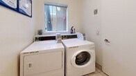 Located at 4230 S Centinela Ave in Los Angeles, California, this dedicated laundry room offers a practical and efficiently organized space for residents. The room is compact yet functional, housing coin-operated WASH-brand washing machines and dryers positioned side by side along one wall. Each unit features a digital control panel, providing straightforward operation for users. A small frosted window centered above the machines allows natural light to filter into the room, contributing to a bright, clean atmosphere. The walls are finished in a simple white paint, and the floor is laid with classic light-toned ceramic tiles, making the space easy to maintain. Informational signage is displayed on the wall near the machines, offering usage instructions and guidelines for residents. A solid white entry door with a standard lever handle provides access to the room. The overall design is utilitarian and straightforward, prioritizing functionality and ease of use. This laundry facility serves as a convenient shared amenity, providing residents with on-site access to essential laundry services without leaving the property.