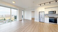 Located at 2215 Sheridan Park Drive in Mississauga, this well-appointed 2-bedroom, 2-bathroom unit offers a bright and contemporary living experience across a thoughtfully designed single floor. Light-toned hardwood flooring flows seamlessly throughout, complementing the clean white walls and modern finishes that define the space.

The open-concept living and dining area is expansive and sun-filled, anchored by floor-to-ceiling windows and sliding glass doors that lead to one of two private balconies. The elevated position of the unit provides sweeping views of the surrounding Mississauga landscape. The kitchen features white cabinetry, stainless steel appliances, and track lighting, integrating naturally with the living area.

A hallway connects the private quarters, where two well-proportioned bedrooms each benefit from large sliding glass doors opening to balcony access, filling the rooms with natural light and outdoor views. Both bathrooms are finished in crisp white tile with soaker tub-shower combinations, open shelving, and polished chrome fixtures. The hallway includes mirrored sliding closet doors, adding both storage and a sense of depth. The overall ambiance is clean, modern, and light-filled throughout.