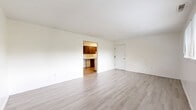 Located at 90 Juanita Ct in Springboro, Ohio, this two-bedroom, single-floor home offers a well-organized and efficient layout. The interior is finished with light-toned luxury vinyl plank flooring throughout, complemented by crisp white walls and clean white trim, creating a bright and cohesive aesthetic across all rooms.

The living room is an open, generously sized space that connects directly to the galley-style kitchen. The kitchen features rich dark-stained wood cabinetry lining both walls, white laminate countertops, a built-in sink, and white appliances including an electric range and refrigerator — offering ample storage and workspace in a functional corridor layout.

The spacious primary bedroom provides a comfortable retreat, complete with a closet. The second bedroom is well-proportioned and includes a window with blinds that allows natural light and views of the surrounding greenery. Both bedrooms share access to the home's bathroom, which is visible from the bedroom corridor.

Throughout the home, the neutral color palette and consistent flooring lend a clean, move-in-ready feel. The layout, as seen in the dollhouse view, is compact yet practical, with rooms arranged to maximize usability within the single-story footprint. This home is ideal for those seeking straightforward, low-maintenance living in Springboro.