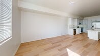 Located in Riverside, CA, Unit 308 at 3644 Harrison St is a thoughtfully designed one-bedroom, one-bathroom residence that balances modern aesthetics with functional living. Light wood plank flooring runs throughout the entire unit, creating a warm and cohesive feel from room to room.

The open-concept living and kitchen area serves as the heart of the unit. The kitchen is a standout feature, outfitted with crisp white shaker cabinetry, light quartz countertops, a stainless steel undermount sink, and a full suite of stainless steel appliances including a French door refrigerator with ice dispenser, a range with microwave, and a dishwasher. A large center island provides additional prep space and a natural gathering point.

The living area flows seamlessly from the kitchen, offering a bright, open canvas with clean white walls and recessed lighting. A glass-paneled door leads to a private exterior access point, allowing natural light to fill the space.

The bedroom is a well-proportioned retreat featuring a window with outdoor views and a dedicated walk-in closet with built-in shelving and hanging rods. The bathroom includes a full soaking tub and shower combination with classic fixtures. A hallway connects the living areas to the private spaces, completing this clean and contemporary floor plan.