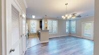 Located at 1006 Cider Mill Loop in Weaverville, NC, this efficiently designed one-bedroom, two-bathroom home offers a thoughtful single-level layout. The open-concept living and dining area is bright and welcoming, featuring hardwood-style flooring, crown molding, and a stylish chandelier. Multiple windows dressed with blinds fill the space with natural light, creating an airy atmosphere throughout.

The kitchen is well-appointed with rich dark cabinetry, granite countertops, stainless steel appliances including a refrigerator, microwave, and range, and a peninsula that connects seamlessly to the living area. Tile flooring grounds the kitchen space, which also benefits from ample cabinet storage and a bright window overlooking the outdoors.

The bedroom is a comfortable, light-filled room with hardwood-style flooring, neutral walls, and access to a spacious walk-in closet outfitted with wire shelving and hanging rods for generous storage. Both bathrooms mirror the kitchen's design aesthetic, showcasing dark vanity cabinetry, granite countertops, large tile-surround tub and shower combinations, and tile flooring. The overall palette of warm neutrals, consistent finishes, and coordinated fixtures lends the home a cohesive, polished character throughout.