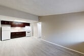 Located at 3030 Continental Colony Pkwy in Atlanta, GA, this one-bedroom, one-bathroom unit offers a practical and efficient single-floor layout. The open-concept living area and kitchen share a continuous light wood-style vinyl floor, creating a seamless and easy-to-maintain space. The kitchen is equipped with rich dark cabinetry, white appliances including a range and refrigerator, and a built-in sink with overhead lighting, providing ample storage and functionality. Neutral gray walls throughout lend a clean, modern feel to the interior.

The living area is bright and open, with a window at the entry allowing natural light to filter in. The bedroom features soft wall-to-wall carpeting, crown molding, a ceiling fan with light fixture, and a window with views of the surrounding greenery. A dedicated closet provides convenient storage within the bedroom. The full bathroom includes a dark-cabinet vanity with a white countertop, a tub and shower combo with a curtain rod, tile-style flooring, and a toilet, all finished in a clean, neutral palette. A utility room rounds out the layout, adding practical storage or laundry functionality to this well-organized Atlanta residence.