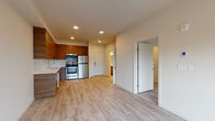 Located at 3214 Broadway in Everett, WA, this thoughtfully designed single-floor unit offers a clean, modern aesthetic throughout. Light-toned wood-style flooring runs seamlessly across the open-concept living and kitchen area, creating a cohesive and airy feel. The kitchen is a standout feature, equipped with sleek flat-panel walnut-toned cabinetry extending to the ceiling, a full suite of stainless steel appliances including a refrigerator, range, microwave, and dishwasher, and a crisp white countertop with an undermount sink. Recessed lighting illuminates the space efficiently, complementing the natural light that filters through large windows. The living area is spacious and open, anchored by a ceiling fan and a generously sized window that offers views of the surrounding neighborhood. The bedroom is a well-proportioned, tranquil retreat with its own ceiling fan, a large window bringing in natural light and outdoor views, and access to a closet. The bathroom is finished with a wood-toned vanity, white countertop, a large mirror with overhead lighting, and light wood-look tile flooring. Throughout the unit, a neutral color palette and modern finishes create a clean, inviting atmosphere well-suited for comfortable everyday living.