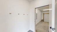 Located at 2130 S 18th Ave in Bozeman, Montana, this contemporary three-story townhome offers a well-organized layout spread across three distinct levels. The ground floor is anchored by a spacious attached garage with polished concrete flooring, bright fluorescent lighting, an automatic garage door opener, and built-in storage including a closet and electrical panel. A dedicated mudroom entry off the garage features wall-mounted coat hooks, providing a practical transition space into the home. The main living level showcases a modern kitchen fitted with light wood cabinetry, white upper cabinets, quartz countertops, a subway tile backsplash, and stainless steel appliances including a refrigerator, range, and built-in microwave. Light luxury vinyl plank flooring runs throughout the main and upper levels, creating a cohesive and easy-to-maintain aesthetic. A full bathroom on this level features a wood-toned vanity with white countertop, undermount sink, and a large mirror. The upper floor hosts well-proportioned bedrooms bathed in natural light through large windows, with recessed ceiling lighting adding a clean, modern touch. The bright, neutral color palette and consistent finishes throughout give the home a fresh, move-in-ready feel suited to Bozeman's active lifestyle.
