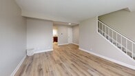 Located in Columbus, Indiana, this two-story home offers a thoughtfully designed layout across two floors, combining comfortable living spaces with modern finishes throughout. The main level features an open living room with light wood-look luxury vinyl plank flooring, neutral warm-gray walls, and clean white trim, creating a bright and welcoming atmosphere. A staircase connects the floors, and hallways on each level provide easy circulation throughout the home. The kitchen is a standout feature, showcasing rich dark wood cabinetry, granite-style countertops, a classic white subway tile backsplash, stainless steel appliances including a gas range and dishwasher, and a bright window that fills the space with natural light. Both full bathrooms are finished with wood-look LVP flooring and include a tub-shower combination. The two bedrooms are carpeted and bathed in natural light from multiple windows with blinds. The primary bedroom includes a spacious double-door closet, while the second bedroom also features closet storage. Soft neutral tones and consistent finishes throughout create a cohesive, move-in ready environment that is both practical and comfortable.