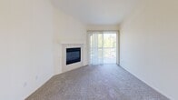 Located at 241 W Buchanan Rd in Pittsburg, CA, this 2-bedroom, 2-bathroom residence offers a practical and comfortable single-floor layout. The living room is a standout space, featuring vaulted ceilings, plush carpet, a tile-surround fireplace, and a sliding glass door that opens to a private patio, allowing for natural light and outdoor views. A ceiling fan adds comfort to the adjoining area.

The kitchen is open to the living space via a breakfast bar counter, offering warm honey-toned cabinetry, white appliances including a range, microwave, refrigerator, and dishwasher, and tile flooring for easy maintenance.

The primary bedroom is generously sized and features mirrored sliding closet doors and soft carpet flooring. The second bedroom also includes a full-width sliding closet and vertical blinds for light control. Both rooms maintain a clean, neutral palette.

The two bathrooms are finished with matching warm cabinetry, tile flooring, and white fixtures. One includes a full tub-shower combo with a vanity mirror and lighted fixture above. The second bath features a window for natural ventilation. A connecting hallway ties the layout together efficiently, making this a well-organized and functional home.