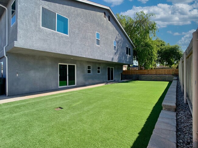 Apartamentos disponibles con patio trasero privado de 750 pies cuadrados con césped artificial. - 1051 Greenfield Dr