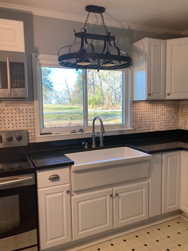 Cocina con fregadero estilo granja y encimeras de granito. - 2227 Wildcat Creek Rd