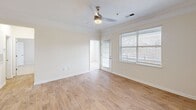 Located at 9500 Muirfield Club Rd in Raleigh, NC, this 2-bedroom, 1-bathroom single-floor home offers a practical and comfortable layout with well-appointed finishes throughout. The kitchen is a standout feature, showcasing rich wood cabinetry, granite countertops, a subway tile backsplash, and a full suite of stainless steel appliances including a range, microwave, and refrigerator. Light hardwood-style flooring runs through the kitchen and living areas, lending a warm, cohesive feel. The living room is bright and open, benefiting from large windows that invite natural light, crown molding accents, and a ceiling fan overhead. A door from the living area provides additional access to the exterior. Both bedrooms are carpeted and fitted with ceiling fans. The primary bedroom is generously sized with direct access to the bathroom and includes a walk-in closet, while the second bedroom features a window with natural light. The bathroom is clean and functional, offering a tub/shower combination with classic checkered tile accents, a wood-tone vanity with granite countertop, and hardwood-style flooring. Two closets and a connecting hallway complete the efficient floor plan of this well-maintained Raleigh home.