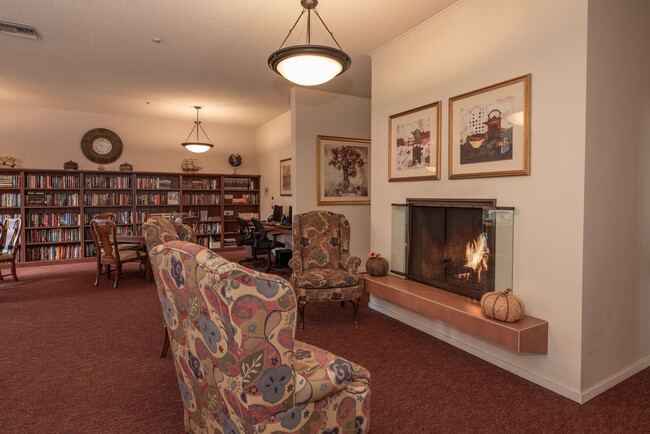 Biblioteca y chimenea en el área común - Roseville Commons Senior Living