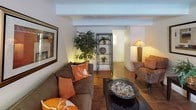 This single-floor residence offers a thoughtfully designed layout that balances comfort and functionality across its key living areas. The living room features rich hardwood-style flooring, exposed beam detailing along the ceiling, and a textured ceiling finish, creating a warm and inviting atmosphere. A large window allows natural light to fill the space, complementing the open flow into the dining area, which is outfitted with a ceiling fan and a sliding glass door that connects to the exterior. The kitchen is well-equipped with dark wood cabinetry, granite-style countertops, and full appliances including a refrigerator and dishwasher, offering ample storage and prep space. The bedroom is generously sized with plush wall-to-wall carpeting, exposed beam ceiling details, and a spacious walk-in closet with built-in shelving and hanging rods. The bathroom presents a clean, modern aesthetic with hardwood-style flooring, a granite-topped vanity with rich wood cabinetry, and a separate bathtub with tiled surround. Throughout the residence, neutral tones and consistent design choices create a cohesive and comfortable living environment.
