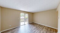 This classic 1-bedroom, 2-bathroom residence in Gardendale, Alabama, offers a well-organized single-floor layout designed for comfortable everyday living. The living room is a bright, open space featuring wood-look plank flooring and a sliding glass door that opens to a private balcony overlooking lush greenery, allowing natural light to flow freely into the room. Neutral warm-beige walls and textured ceilings carry throughout the home, lending a cohesive and welcoming ambiance. Adjacent to the living area, the dining room features a pendant light fixture overhead and direct sightlines into the kitchen, creating a seamless connection between spaces. A hallway closet with louvered bifold doors provides convenient storage. The galley-style kitchen is efficiently arranged with white cabinetry trimmed in warm wood accents, tile flooring, and full appliances including a range, dishwasher, and refrigerator. The spacious bedroom is carpeted for comfort and includes direct access to a private bathroom as well as a dedicated closet. Both bathrooms are cleanly finished, one featuring a shower-tub combo with tile flooring, and the other offering a vanity with wood-accented cabinetry and well-lit mirror. Overall, the home presents a classic, functional design suited for easy, comfortable living.