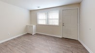 Located at 128 B Nunnery Ln in Catonsville, Maryland, this two-floor home offers a clean, move-in-ready interior finished with a consistent neutral color palette and light-toned luxury vinyl plank flooring that flows throughout the living areas and bedrooms. The open layout creates a sense of spaciousness, with each room benefiting from natural light streaming through blinded windows. The kitchen is a functional highlight, featuring rich warm-toned wood cabinetry, granite-style countertops, a subway tile backsplash, and a full suite of stainless steel appliances including a gas range and dishwasher. Light ceramic tile flooring in the kitchen complements the overall design aesthetic. The bathroom is neatly appointed with a white vanity, tub-shower combination, and matching light tile flooring, maintaining the home's cohesive, fresh look. Bedrooms are generously proportioned with ample wall space and natural light from exterior-facing windows. The entry level features a welcoming foyer with direct exterior access and a window that brings in additional natural light. Clean white trim and baseboards throughout add a polished finish to every room, contributing to the home's bright, well-maintained ambiance.