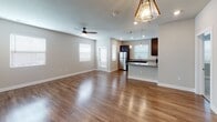 Located at 901 E Oak St in Mahomet, IL, this single-floor unit offers a well-designed, open-concept layout that seamlessly connects the living and kitchen areas. The living room is spacious and bright, featuring gleaming hardwood-style flooring, a ceiling fan with light fixture, and windows fitted with blinds that allow natural light to fill the space. Pendant lighting accents the transition into the kitchen area, adding a modern touch.

The kitchen is thoughtfully appointed with rich, dark cabinetry, granite countertops, and a full suite of stainless steel appliances including a range, microwave, dishwasher, and refrigerator. A large window above the sink brings in additional natural light, while the extended peninsula provides extra counter space and casual seating potential.

The bedrooms are finished with soft, neutral-toned carpet, ceiling fans, and windows with blinds, creating comfortable, well-lit retreats. In-unit laundry hookups are also visible, adding everyday convenience.

The bathrooms feature wood-look vinyl flooring, dark vanity cabinetry with granite countertops, and accessible grab bars, reflecting a practical yet polished design. Throughout the unit, a consistent neutral color palette and clean finishes create a cohesive, modern aesthetic.