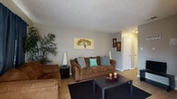 This single-floor residence offers a practical and well-organized layout that makes efficient use of its space. The living room serves as the heart of the home, featuring tile flooring, a textured ceiling, and a front entry door flanked by a sliding glass door that allows natural light to filter in. The room comfortably accommodates a full seating arrangement and includes wall art and decorative greenery that add a warm, inviting atmosphere.

The bedroom is a cozy, well-appointed retreat with tile flooring, a ceiling fan with light fixture, and a textured ceiling. Decorative wall accents and ample space for a full bed and dresser make it a functional and comfortable space.

The kitchen is compact and efficiently designed, equipped with an electric range and overhead ventilation, granite-look countertops, and cabinetry for storage. The layout maximizes the available space for everyday cooking needs.

The bathroom is clean and bright, featuring tile flooring, a vanity with countertop, a toilet, and a shower-tub combination with a decorative curtain. A small window provides ventilation and natural light.

Throughout the residence, consistent tile flooring, neutral gray walls, and textured ceilings create a cohesive and easy-to-maintain interior. The overall ambiance is functional, tidy, and well-suited for comfortable everyday living.