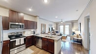 Located in Rockwall, TX, this thoughtfully designed 2-bedroom, 2-bathroom residence offers a comfortable and stylish single-floor layout. The open-concept living and dining area features warm hardwood-style flooring, crown molding, and neutral tones that create a bright and welcoming ambiance. A sliding glass door connects the living space to a private balcony, allowing natural light to pour in.

The kitchen is a standout feature, outfitted with rich dark wood cabinetry, granite countertops, stainless steel appliances, and a peninsula with bar seating — ideal for casual dining or entertaining. Recessed lighting and wood-style flooring complete the polished look.

The primary bedroom is generously sized, featuring plush carpet, a ceiling fan, and access to a walk-in closet. Its en-suite bathroom includes a glass-enclosed shower with wood-style flooring for a clean, modern feel. The second bedroom is equally comfortable, also carpeted with a ceiling fan and natural light from a large window. The second bathroom offers a full tub-shower combination.

A hallway connects all rooms efficiently, contributing to a functional and cohesive floor plan. Throughout the residence, a consistent palette of soft neutrals, crown molding, and quality finishes lend the space an understated yet refined character.