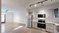 Located at 8700 Seeing Trail Rd in Wake Forest, NC, this thoughtfully designed one-bedroom, one-bathroom unit offers a smart and functional layout across a single floor. Polished concrete flooring runs throughout, giving the space a modern, industrial aesthetic that is both durable and visually striking.

The open kitchen is well-appointed with gray shaker-style cabinetry, granite countertops, a classic subway tile backsplash, and a full suite of stainless steel appliances including a refrigerator, electric range, over-the-range microwave, and dishwasher. A farmhouse-style sink and built-in wine rack add distinctive character. Track lighting overhead provides ample illumination throughout the kitchen and living area.

The living area features French doors with transom windows that invite natural light and provide direct outdoor access. The bedroom is a comfortable size, complete with a ceiling fan, natural light from a window with blinds, and direct access to both a closet and the bathroom. The closet is outfitted with built-in wooden shelving for organized storage.

The bathroom includes a tub-shower combination, a granite-topped vanity, and coordinating gray cabinetry. A dedicated laundry area completes the unit, adding everyday convenience to this clean and contemporary space.