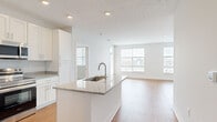 Located at 5151 Ebright Rd in Canal Winchester, Ohio, this single-floor residence offers four bedrooms, two bathrooms, and a thoughtfully designed open layout. The kitchen is a standout feature, showcasing crisp white shaker cabinetry, granite countertops, a center island with an undermount sink, and a full suite of stainless steel appliances including a refrigerator, range, microwave, and dishwasher. Recessed lighting and hardwood-style flooring complete the kitchen's clean, modern aesthetic. The kitchen flows seamlessly into the living room, which is bathed in natural light through multiple large windows with views of the surrounding neighborhood. The bedrooms are comfortably sized, with the primary bedroom featuring hardwood-style flooring and generous windows, while the additional bedrooms are finished with plush carpeting and natural light. Both bathrooms are appointed with granite-topped vanities, white cabinetry, and hardwood-style flooring. A dedicated laundry room accommodates a full-size washer and dryer. Three closets provide ample storage throughout. The home's neutral color palette and consistent finishes create a bright, cohesive ambiance throughout.