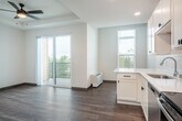 Located at 6231 Williamsburg Way in De Forest, WI, this single-floor, one-bedroom, one-bathroom unit offers a well-designed layout that maximizes every inch of its compact footprint. The entrance leads down a clean, light-filled hallway with wood-look flooring that extends through the main living areas. The kitchen is a standout feature, outfitted with crisp white shaker cabinets, a classic subway tile backsplash, light quartz countertops, and a full suite of stainless steel appliances including a refrigerator, electric range, microwave, and dishwasher. A peninsula counter provides additional workspace and transitions seamlessly into the combined dining and living area, which benefits from recessed lighting and a bright, open feel. The bedroom is carpeted for warmth and comfort, features a ceiling fan with a window for natural light, and includes access to a closet with wire shelving. The bathroom is appointed with a glass-door walk-in shower and wood-look tile flooring, maintaining the clean, modern aesthetic found throughout the unit. A private patio extends the living space outdoors, offering a welcome retreat. The overall design is fresh and contemporary, with neutral tones and quality finishes that create a cohesive, move-in-ready living environment.