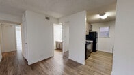 This single-story residence offers a practical and comfortable layout across two bedrooms, two bathrooms, and a thoughtfully arranged set of living spaces. The combined living and dining area serves as the heart of the home, featuring plush carpet flooring, a ceiling fan, a tiled fireplace, and a sliding glass door that invites natural light and outdoor access. A front entryway with wood-look vinyl flooring transitions smoothly between the main living zone and the kitchen.

The galley-style kitchen is efficiently designed with gray cabinetry, laminate countertops, a double stainless steel sink, and black appliances including a refrigerator, electric range, and dishwasher. Wood-look flooring runs throughout the kitchen, adding a cohesive feel.

Both bedrooms are carpeted and include ceiling fans and windows with vertical blinds. The primary bedroom offers a generous footprint with ample space for furnishings. Each bedroom benefits from closet storage, with one featuring a double-door closet. The two bathrooms include tub/shower combinations and wood-look vinyl flooring. A utility room and hallway complete the floor plan, adding functional storage and connectivity throughout the residence. Textured ceilings are consistent throughout the home.