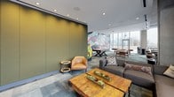 Located at 617 W Division St in Chicago's vibrant Near North Side, this amenity lounge is a dynamic, multi-use space designed for both recreation and relaxation. The layout is thoughtfully divided into distinct zones, seamlessly connected by a cohesive modern aesthetic and varied flooring that transitions between slate-toned tile and rich teal carpet.

A striking large-scale mural anchors the game area, where a foosball table, air hockey table, and classic arcade machines create an energetic atmosphere. Recessed lighting throughout keeps the space well-illuminated, while the bold olive-green accent wall adds depth and color contrast.

The lounge area features a generously sized sectional sofa adorned with eclectic throw pillows, paired with a rustic wood coffee table with live-edge detailing and natural succulent arrangements. A leather accent chair and side table provide additional seating. Adjustable track lighting runs along the ceiling, offering directed illumination across the lounge.

Floor-to-ceiling glass windows wrap around the perimeter, flooding the space with natural light and offering expansive panoramic views of the Chicago skyline and surrounding neighborhoods. A bistro-height table with stools positioned directly at the windows provides an intimate spot to take in the elevated city vistas. The overall ambiance balances an urban, artistic energy with comfortable, inviting design elements.
