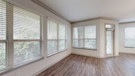 Located at 1200 S Dairy Ashford Rd in Houston, TX, this one-bedroom, one-bathroom unit offers a thoughtfully designed single-floor layout with a comfortable and functional living environment. The living areas feature rich wood-style flooring and multiple large windows dressed with blinds, flooding the space with natural light and offering pleasant views of surrounding greenery. Built-in shelving near the entryway adds convenient storage from the moment you step inside.

The kitchen is well-appointed with tan cabinetry, white subway tile backsplash, light countertops, and stainless steel GE appliances including a range, over-the-range microwave, and dishwasher. The layout provides ample counter and cabinet space for everyday cooking needs.

The bedroom is carpeted for comfort, features a ceiling fan, a window for natural light, and connects directly to a spacious walk-in closet with built-in shelving. The full bathroom is generously sized, offering dual sinks with wide countertops, large mirrors, wood-style flooring, and a full soaking tub with a tiled surround. A hallway connects the main living areas, completing this well-organized and comfortable single-level home.