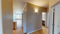 Located at 25668 SW Canyon Creek Rd in Wilsonville, Oregon, this single-floor residence offers a thoughtfully designed layout with a comfortable, functional flow between spaces. The kitchen is a standout feature, equipped with stainless steel appliances including a refrigerator, range, and microwave, complemented by light wood cabinetry, white quartz countertops, a stainless steel undermount sink, and light hardwood-style flooring. A peninsula with additional counter space connects the kitchen to the main living area, which features crown molding, a ceiling fan, a fireplace, and a prominent bay window that fills the room with natural light. Built-in open shelving adds practical storage and character. The bedroom areas are carpeted and benefit from vaulted ceilings, ceiling fans, and sliding glass doors leading to a private balcony with views of surrounding greenery. The bathrooms are finished with light wood-tone cabinetry, white quartz countertops, wood-look flooring, and well-lit vanity mirrors. Additional highlights include louvered closet doors, wall sconce lighting, and a neutral color palette throughout that contributes to a clean, welcoming ambiance.