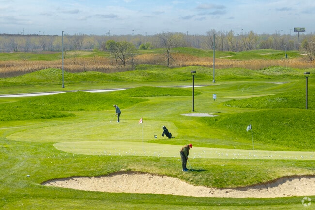 Golfers practice their chip shots on the greens of Harborside International.