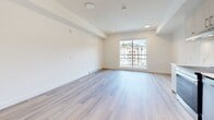 Located at 902 Lytton Street in North Vancouver, BC, this well-appointed studio unit offers a bright and efficiently designed open-plan layout combining the kitchen and living area in a single cohesive space. The interior is finished with light-toned laminate flooring throughout, contributing to a clean, airy aesthetic that maximizes the sense of space.

The kitchen is thoughtfully outfitted with light wood cabinetry, sleek bar-pull hardware, and a marble-effect backsplash that adds a refined touch. White quartz countertops provide ample workspace, while stainless steel appliances — including a refrigerator, dishwasher, built-in oven with cooktop, and an under-cabinet range hood — deliver a fully functional cooking environment. A stacked washer and dryer unit is conveniently tucked into a dedicated alcove off the kitchen.

The living area is open and filled with natural light courtesy of a large sliding window that frames views of the surrounding North Vancouver neighbourhood and mountain backdrop. Recessed and flush-mount ceiling lighting, along with baseboard heating, ensure comfort year-round. The neutral white walls and understated finishes throughout create a versatile canvas well-suited to a variety of furnishing styles. A sliding door closet provides practical storage within the space.
