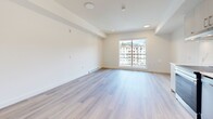 Located at 902 Lytton Street in North Vancouver, BC, this well-appointed studio unit offers a bright and efficiently designed open-plan layout combining the kitchen and living area in a single cohesive space. The interior is finished with light-toned laminate flooring throughout, contributing to a clean, airy aesthetic that maximizes the sense of space.

The kitchen is thoughtfully outfitted with light wood cabinetry, sleek bar-pull hardware, and a marble-effect backsplash that adds a refined touch. White quartz countertops provide ample workspace, while stainless steel appliances — including a refrigerator, dishwasher, built-in oven with cooktop, and an under-cabinet range hood — deliver a fully functional cooking environment. A stacked washer and dryer unit is conveniently tucked into a dedicated alcove off the kitchen.

The living area is open and filled with natural light courtesy of a large sliding window that frames views of the surrounding North Vancouver neighbourhood and mountain backdrop. Recessed and flush-mount ceiling lighting, along with baseboard heating, ensure comfort year-round. The neutral white walls and understated finishes throughout create a versatile canvas well-suited to a variety of furnishing styles. A sliding door closet provides practical storage within the space.