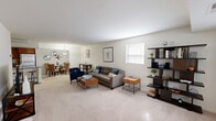 Located at 8253 Townsend St in Fairfax, VA, this single-floor, 1-bedroom, 1-bathroom residence offers a thoughtfully designed layout with a comfortable, functional flow throughout. The open-concept living and dining area is bright and inviting, featuring plush wall-to-wall carpeting, neutral-toned walls, and natural light streaming in through multiple windows. A charming built-in window seat near the front entry adds a cozy architectural detail. The kitchen is well-equipped with warm wood cabinetry, granite countertops, stainless steel appliances including a gas range with microwave above, a full-size refrigerator, and a central island with bar seating — ideal for both everyday cooking and casual dining. Dark tile flooring grounds the kitchen space. The generously sized primary bedroom features soft carpeting, a large window with outdoor views of the surrounding neighborhood, and ample wall space. The full bathroom includes a tub-shower combination with classic white tile surround. A dedicated in-unit laundry closet houses a stacked washer and dryer, adding everyday convenience. With its clean design, practical layout, and desirable location in Fairfax, this residence offers comfortable living in Northern Virginia.