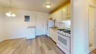 Located at 10-52 Estates Circle in Laconia, New Hampshire, this single-floor unit offers a practical and well-organized layout across several distinct living areas. The entryway welcomes you with light wood-tone laminate flooring that extends throughout the main living spaces, providing a clean and cohesive aesthetic. A closet is conveniently positioned near the front door, offering immediate storage upon entry.

The open living area flows directly from the entry, featuring baseboard heating and neutral walls that create a bright, versatile space. Adjacent to the living area, the kitchen is equipped with white cabinetry, a gas range, a refrigerator, and a double-basin sink. Under-cabinet lighting adds functionality, while the light wood flooring continues seamlessly from the living space into the kitchen. A dedicated utility panel is also accessible within the kitchen area.

The bedroom is finished with wall-to-wall carpet, providing comfort underfoot, and includes a window that allows natural light to fill the room. Baseboard heating ensures year-round warmth. The full bathroom features a tiled tub-and-shower combination, a toilet, and neutral-toned walls with tile flooring, offering a clean and functional space. Overall, the unit presents a straightforward and efficient layout well-suited for comfortable everyday living in the Laconia, NH area.