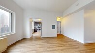 Located at 7 DeKalb Avenue in Brooklyn's vibrant downtown neighborhood, this studio offers a well-designed, single-floor layout that maximizes both function and comfort. Throughout the space, light-toned hardwood flooring creates a warm, cohesive foundation that ties each area together seamlessly.

The open living area is bright and airy, benefiting from large windows that frame impressive views of the New York City skyline, flooding the room with natural light. Clean white walls and a neutral palette enhance the sense of openness throughout. An electrical panel is conveniently recessed into the wall.

The separate kitchen is thoughtfully appointed with dark espresso-toned cabinetry, light gray countertops, and a subtle teal subway tile backsplash. Stainless steel appliances — including a gas range, built-in microwave, dishwasher, and full-size refrigerator — deliver a modern, fully equipped cooking environment. A window in the kitchen provides additional natural light.

A welcoming entryway leads into the main living space, offering a clear sense of arrival. The overall layout is efficiently organized, with a dedicated corridor connecting the living area, kitchen, and additional spaces, making this studio a practical and stylish option in one of Brooklyn's most dynamic and well-connected neighborhoods.