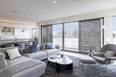 Located in the desirable Westwood neighborhood of Los Angeles, this single-floor residence at 1644 Malcolm Ave showcases a refined modern aesthetic throughout. Light hardwood flooring flows seamlessly across the open-concept living and dining areas, where subtle striped wallcoverings add texture and warmth. The dining space centers around an elegant oval walnut table beneath stylish globe pendant lights, opening directly to a chef's kitchen appointed with high-gloss white cabinetry, a striking marble slab backsplash, quartz countertops, and premium stainless steel appliances including a professional-grade range and French door refrigerator. A media room with a large wall-mounted display and cozy seating provides a dedicated entertainment retreat. The primary bedroom suite features curated abstract artwork, recessed lighting, and a generous walk-in closet with custom shelving and hanging systems. Its en-suite bath is a spa-like sanctuary showcasing floor-to-ceiling marble wall cladding, a freestanding soaking tub with ambient cove lighting, and a glass-enclosed shower. Additional bedrooms are bright and well-proportioned with ample closet space and natural light. A dedicated laundry room rounds out the home with full-size washer and dryer units, a utility sink, and abundant built-in cabinetry.